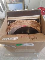 Box containing stacked records in paper sleeves