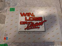 Game box lid showing title graphics and MB logo