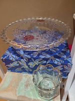 Top view of glass cake stand showing pink floral motif and vase in foreground