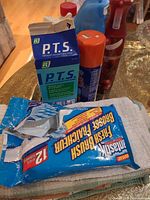 Group of cleaners, air freshener spray and towel pack on table