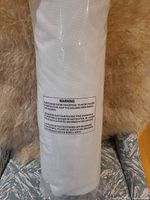 Rolled white king mattress protector in clear plastic