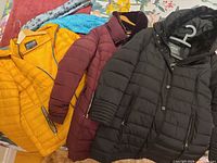 Three coats laid out with scarves visible