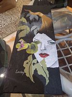 Front view of Lamboy painting showing portrait, snake, foliage and signature