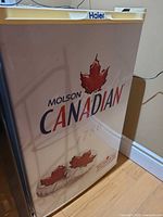 Closed Molson Canadian Haier bar fridge front and side view