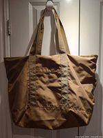 Front view of large beige fabric tote hanging