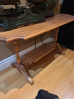 Full view of wooden sofa table showing top, legs, shelf