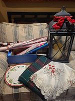 Group of wrapping papers, lantern, plate, tablecloths on chair