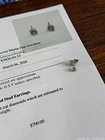Both diamond stud earrings displayed on appraisal sheet