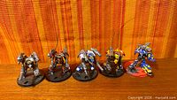 Group shot of five painted Warbringer Nemesis Titan miniatures on bases