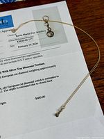 Necklace laid on appraisal document showing overall view