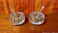 Two cut crystal open salt cellars with spoons inserted, overall lot view