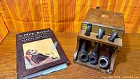 Overall lot view: book, pipe rack/humidor, four pipes