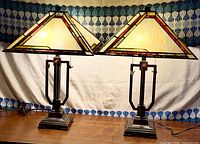 Both lamps side by side on table, shades illuminated