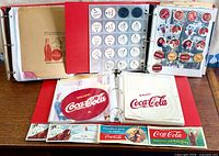 Overview of three open binders with discs and rectangular paper ads visible