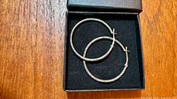 pair of sterling silver hoop earrings inside presentation box