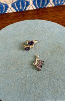 Pendant and one earring front view on fabric mat