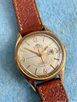 Dial and strap close-up showing Solar branding, red seconds hand, date window, applied indices, leather strap texture.