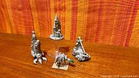 All four pewter miniatures displayed on tabletop