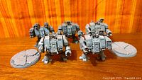 Five assembled dreadnought miniatures with two bases on wooden surface