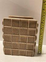 Front view showing checkerboard design and tape measure indicating height ~6.5 in