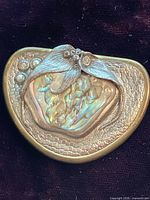 Front view of brooch highlighting abalone shell, leaf detail and bead accents
