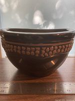 Large glazed black half-round terra cotta planter front view with relief detailing