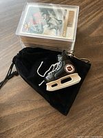 Stacked cards in plastic case and miniature skate keychain on pouch