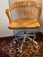 Front view of wooden chair on metal rolling base