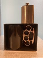 Mug in box with hip flask beside it