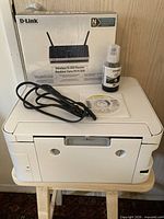 Top view of Epson ET-2760 printer, sealed D-Link N300 router box, Epson 502 ink bottle and power cord