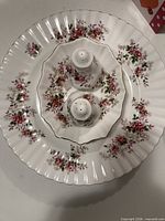Stack of five plates with gold-trimmed scalloped edges and floral design