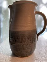 Full side view of pitcher showing overall form, glaze colors and handle