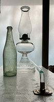 Kerosene lamp, bottle and towel bar grouped