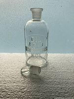 Front view showing embossed lettering and detached stopper