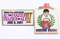 Front view of both boxing promotional pins showing graphics and text