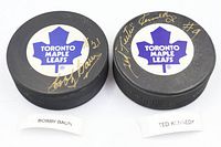 Top view showing both pucks with Toronto Maple Leafs logos and gold autographs