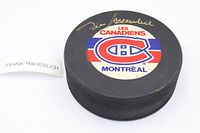 Top view of puck showing Canadiens logo and gold autograph