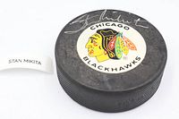 Top view of puck showing Blackhawks logo and Stan Mikita autograph