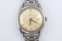 Front view showing dial, hands, indices, brand name, date window