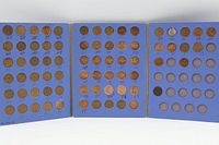 Folder opened showing three interior panels with numerous copper cents installed, empty slots visible