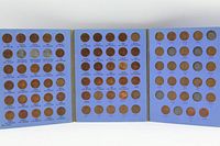 Open album showing full spread of three panels with inserted cents