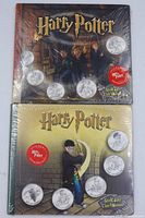 Front view of two sealed Harry Potter Royal Canadian Mint medallion sets showing cover art and coins