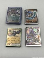 Four stacks of Pokémon cards, tops showing Great Tusk ex, two 210 HP V cards, and a 280 HP VSTAR, some in protective sleeves