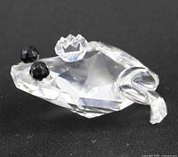 Front view of clear crystal frog figurine showing black crystal eyes and faceted body
