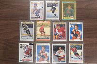Front view of eleven sleeved hockey cards showing player images and overall condition