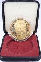 Coin in capsule seated in display case showing portrait and inscriptions