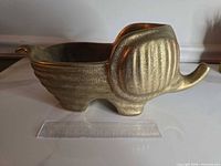 Side view of gold elephant planter with ruler for scale