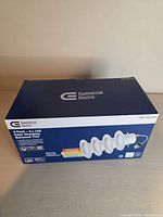 Front of box showing Commercial Electric branding and four-pack image