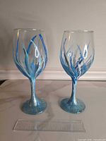 Front view of both hand-painted wine glasses with ruler for scale