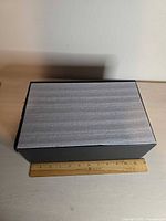 Foam-covered outer shipping sleeve measured against ruler